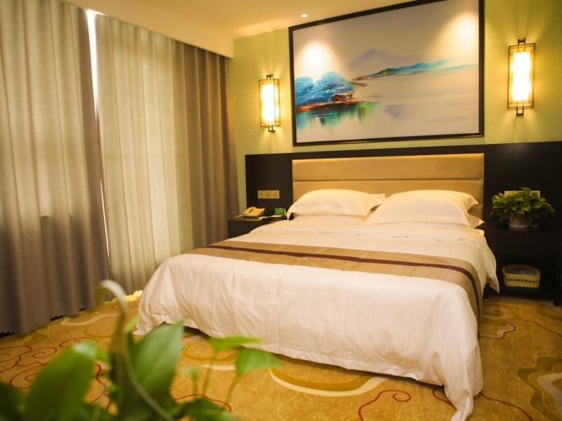 um quarto com uma cama grande num quarto de hotel em GreenTree Alliance Texas Ningjin County Zhengyang Road Debai Plaza Hotel em Dezhou