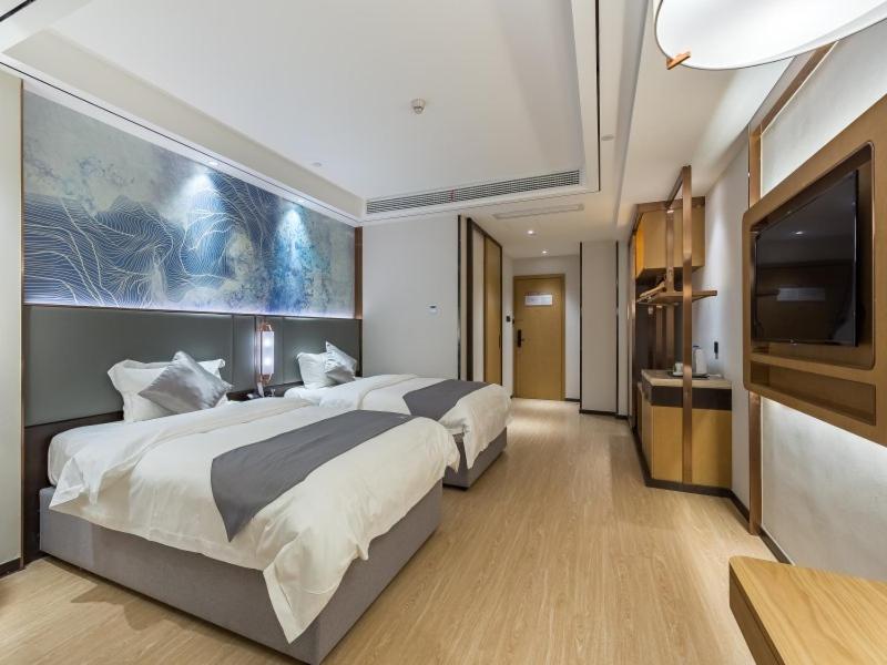 a hotel room with two beds and a flat screen tv at GreenTree Eastern Xuzhou High Speed Railway Station West Exit Station Hotel in Xuzhou