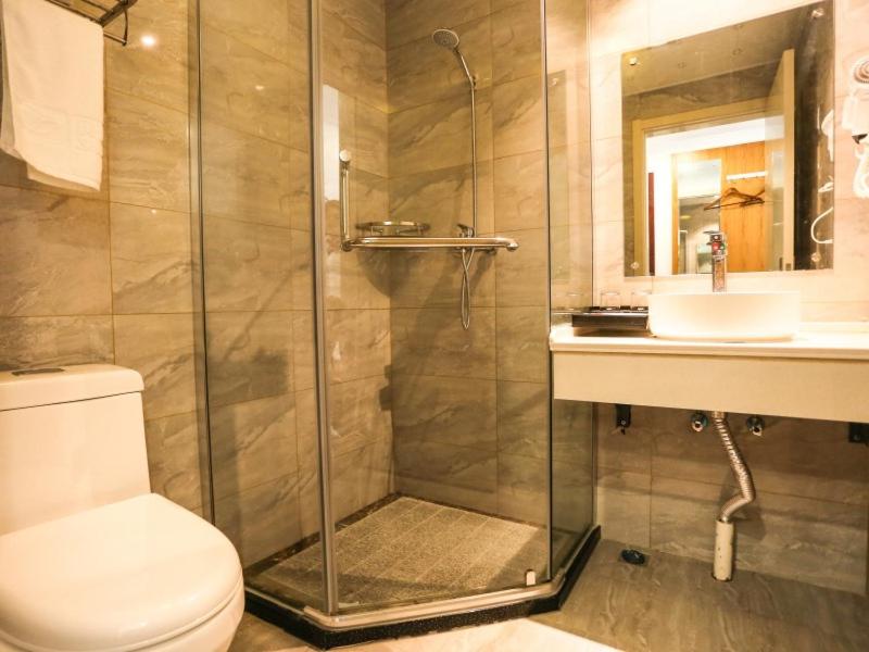 y baño con ducha, aseo y lavamanos. en Shell Hefei Feidong County Baogong Avenue Yulong Mansion Hotel en Hefei