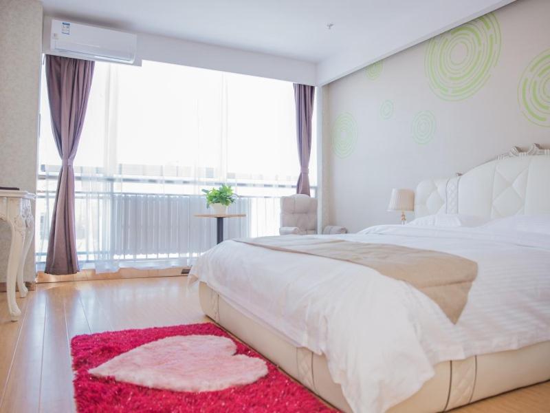 - une chambre blanche avec un grand lit et un tapis rouge dans l'établissement GreenTree Inn Chengde Fengning Manchu Autonomous County Ningfeng Road Express Hotel, à Fengning