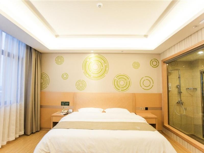 um quarto com uma cama grande e um chuveiro em GreenTree Inn Fuyang Linquan County Economic Development Zone Xingye Road Hotel em Fuyang