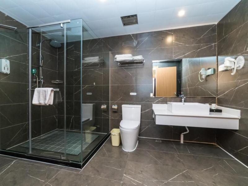 a bathroom with a sink and a shower and a toilet at GreenTree Inn Binzhou Yangxin County Bus Station Lubei Da Market Business Hotel in Binzhou