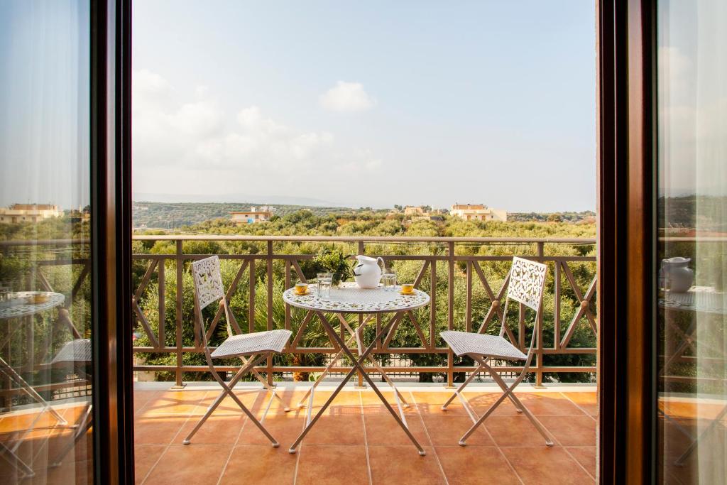 una mesa y sillas en un balcón con vistas en Eleon Residence, en Stavromenos