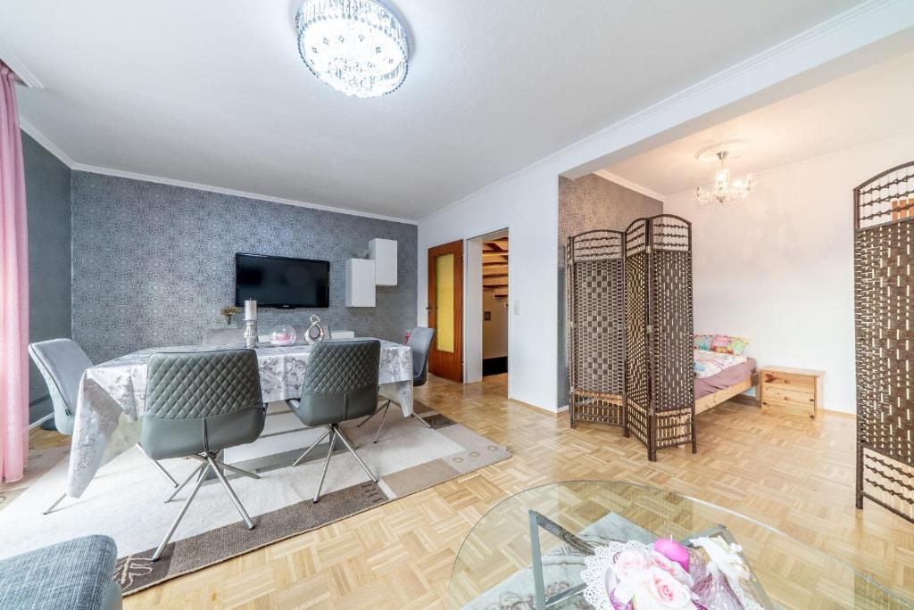 een woonkamer met een tafel en stoelen en een slaapkamer bij Private House in Hannover