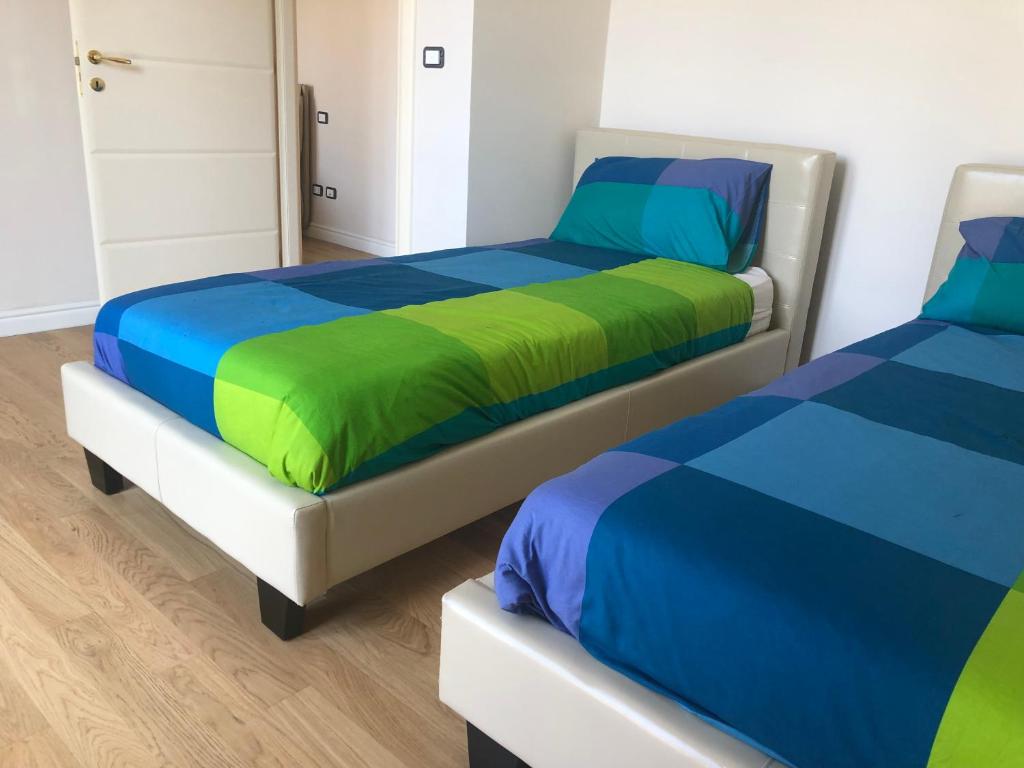 two beds in a bedroom with blue and green at VIOLA HOME in Salerno