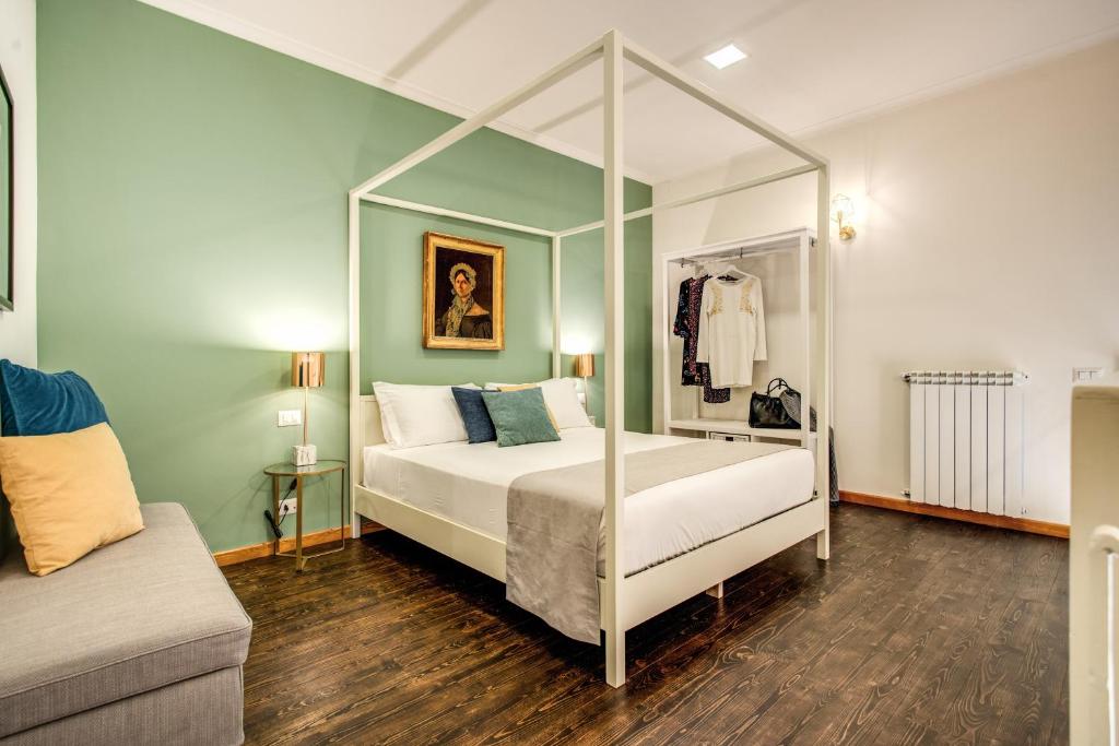 1 dormitorio con cama con dosel y sofá en Casa Hosteno en Nápoles