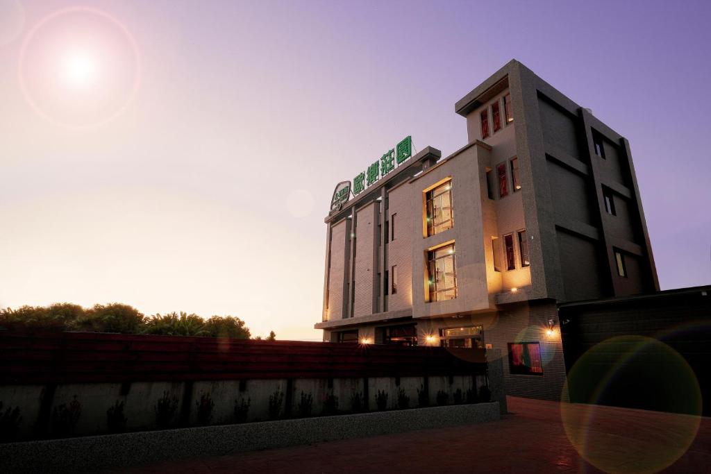 un edificio con la puesta de sol detrás de él en Ouxiang Manor Hotel en Yuanlin