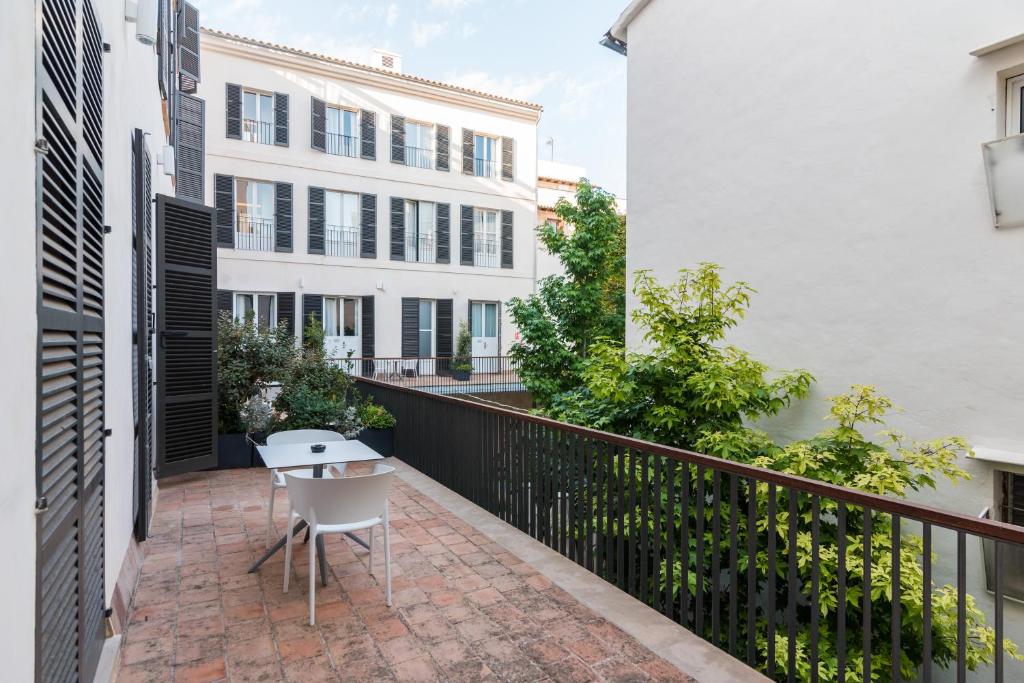 a balcony with a table and a white chair at ICON Rosetó in Palma de Mallorca