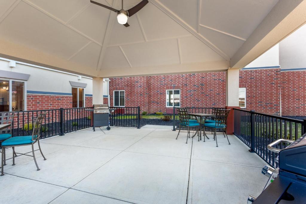 a patio with chairs and tables and a brick building at Candlewood Suites Bethlehem South by IHG in Bethlehem
