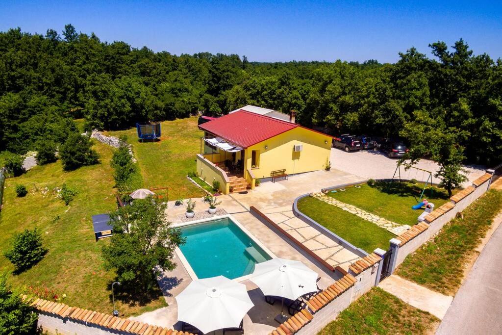 una vista aérea de una casa con piscina en Sunny yellow house with a pool, en Štokovci