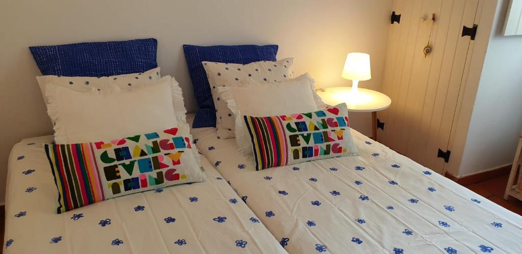 a bedroom with two beds with white sheets and pillows at Comporta House in Comporta
