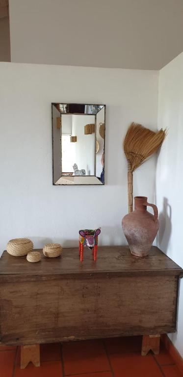 a table with a mirror and a vase on it at Comporta House in Comporta