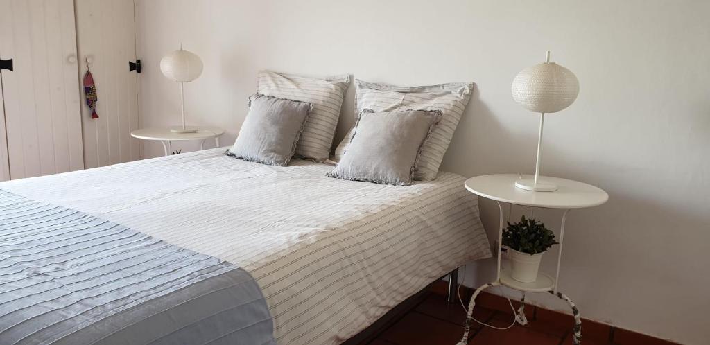 a bedroom with a bed with white sheets and pillows at Comporta House in Comporta