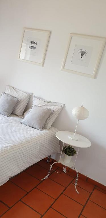a bedroom with a white bed and a table at Comporta House in Comporta