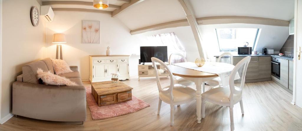 ein Wohnzimmer mit einem Tisch und Stühlen sowie eine Küche in der Unterkunft Champagne cocoon in Épernay