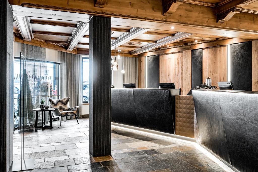 a lobby with black booths and a table and chairs at Hotel Edelweiss & Gurgl in Obergurgl