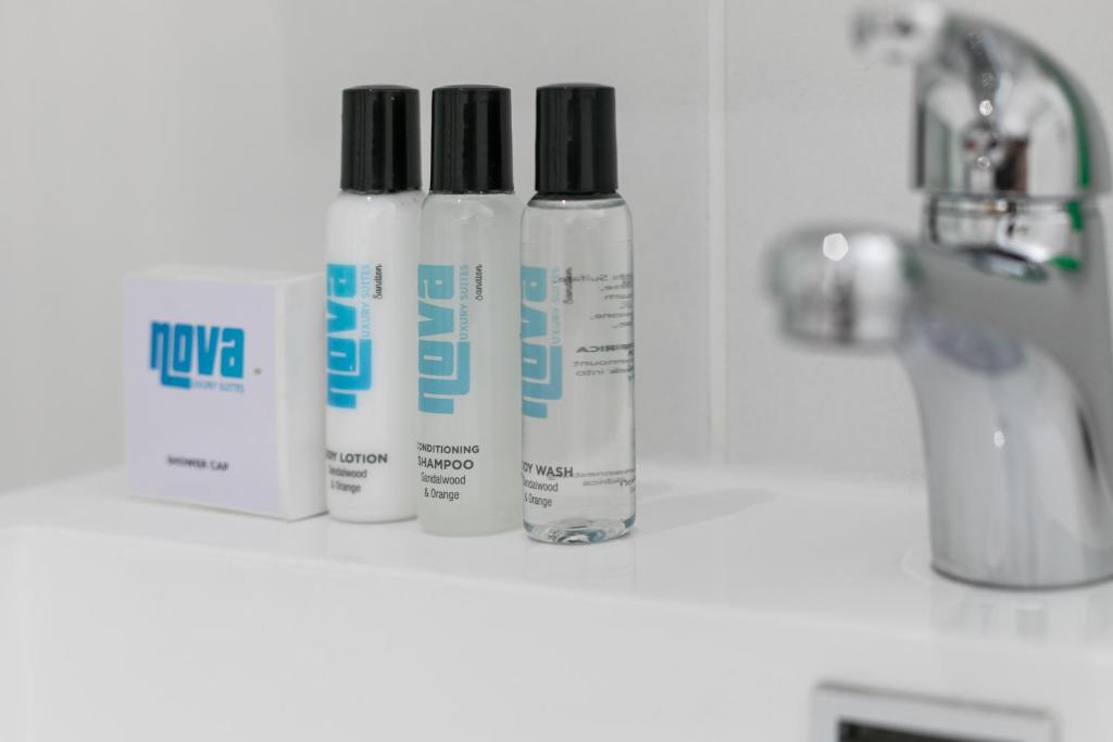 three bottles ofodorizers sitting on a shelf in a bathroom at Nova Luxury Suites Fourways in Johannesburg