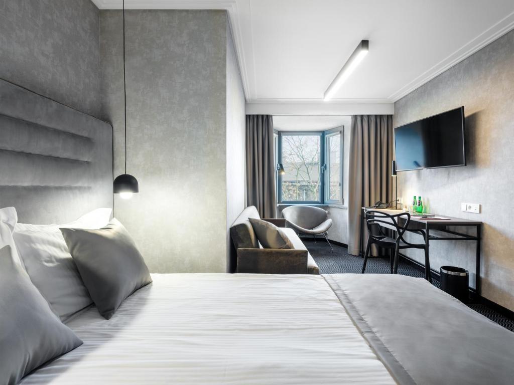 a hotel room with a bed and a desk at Hotel Logos Kraków in Krakow