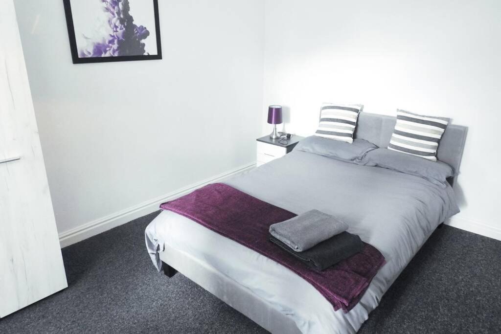 ein Schlafzimmer mit einem großen weißen Bett mit Kissen in der Unterkunft Outstanding and Spacious modern 4 bedroom house in Hull