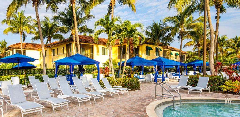 a group of chairs and umbrellas next to a pool at Naples Bay Resort and Marina in Naples