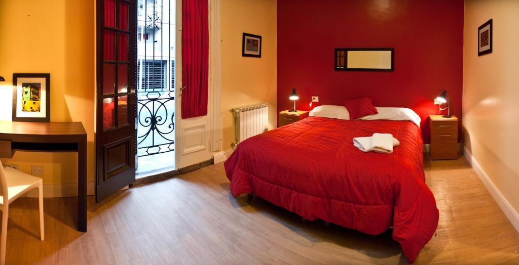 a red bedroom with a bed and a desk at Sabatico Suites in Buenos Aires
