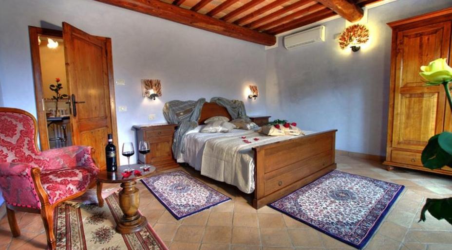 a bedroom with a bed and a table and a chair at Agriturismo Ardene in Montepulciano