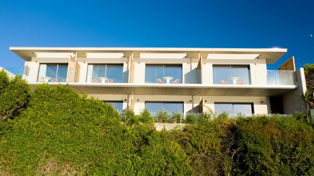 a white house on the hill with bushes at Hotel le Jardin d'Emile in Porticcio
