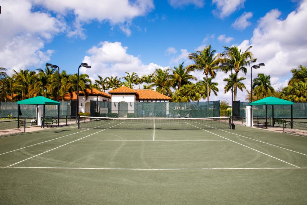 a tennis court with palm trees in the background at Naples Bay Resort and Marina in Naples