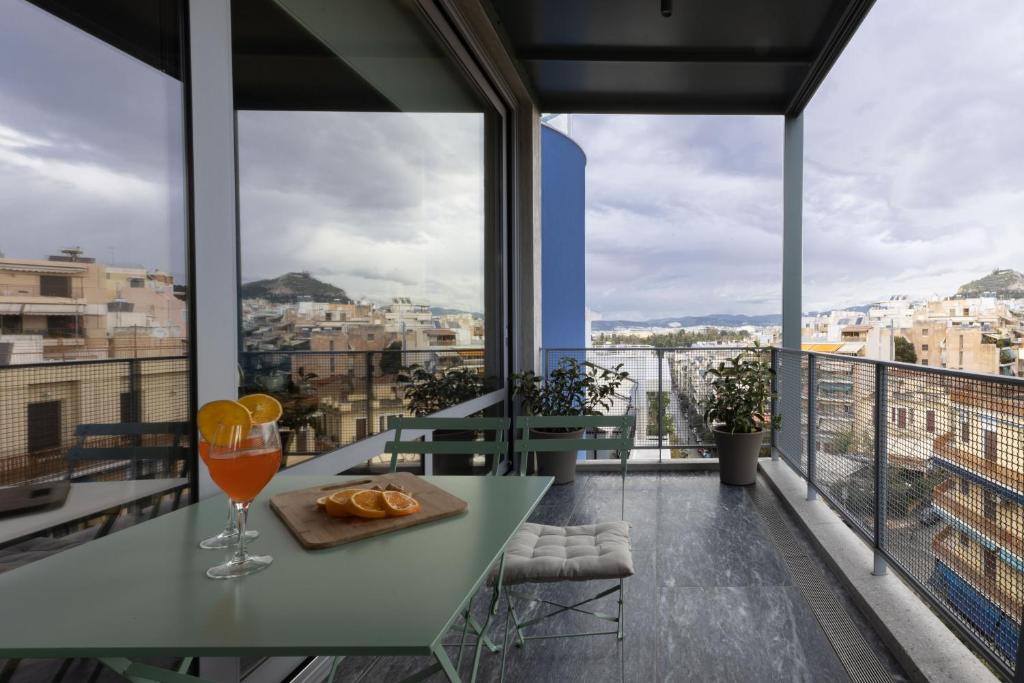 een tafel met een glas sinaasappelsap op een balkon bij Athens BlueBuilding in Athene