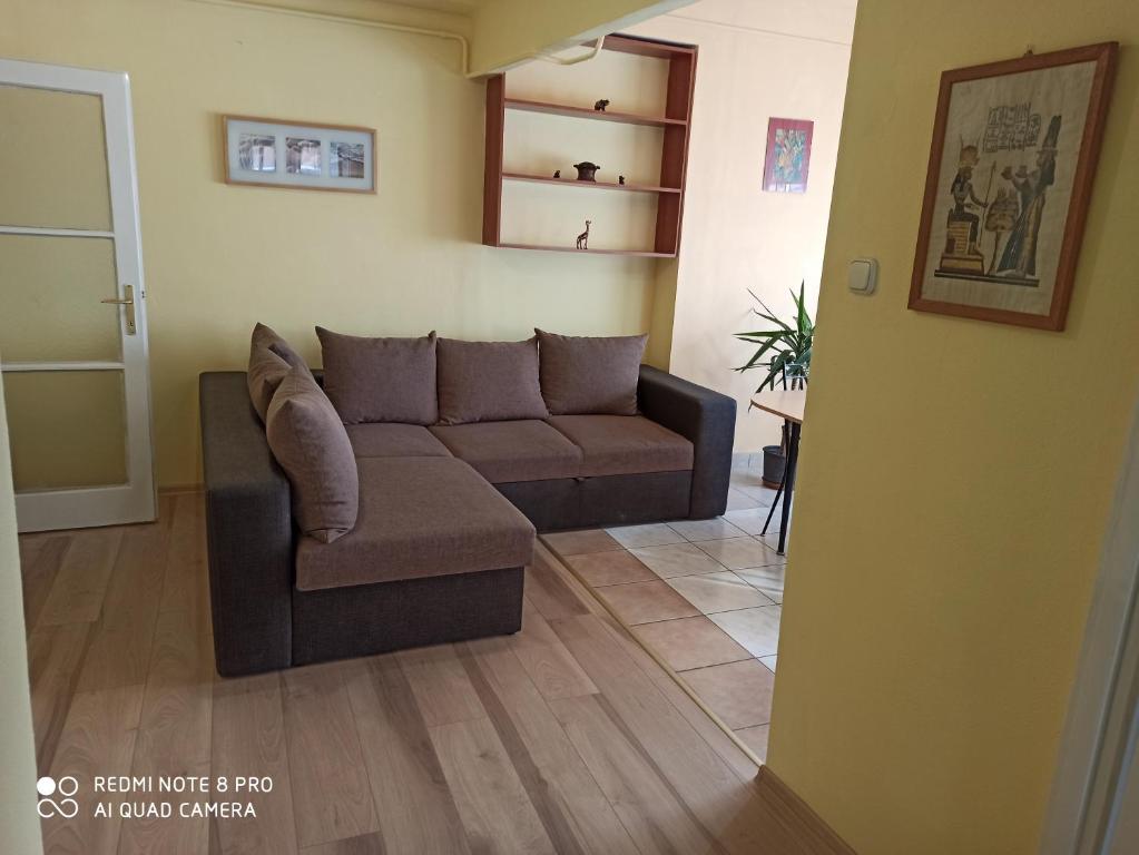 uma sala de estar com um sofá e uma mesa em Centrum 2 apartman em Szolnok