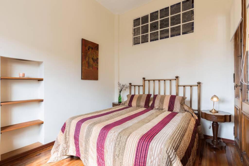 um quarto com uma cama com um cobertor listrado em The Wall 002 Loft sobre la histórica Muralla en la Ciudad Vieja em Montevidéu