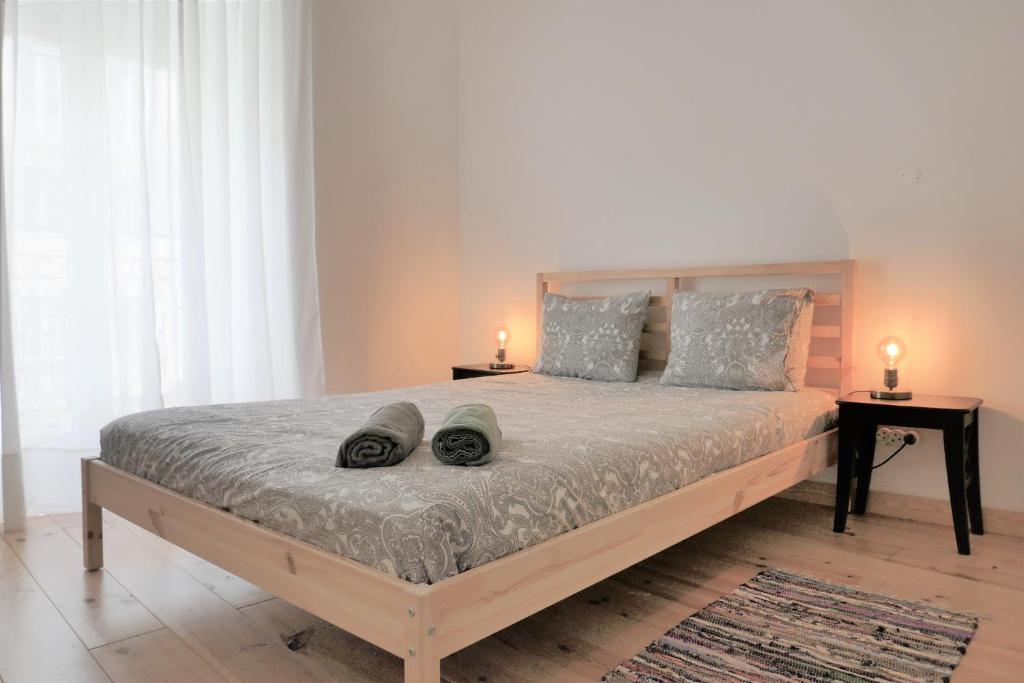 TT Anjos Lisbon Rooms في لشبونة: غرفة نوم بسرير كبير وعليها شمعتين