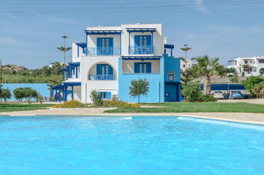 a villa with a swimming pool in front of a house at Agyra Studios in Agios Prokopios