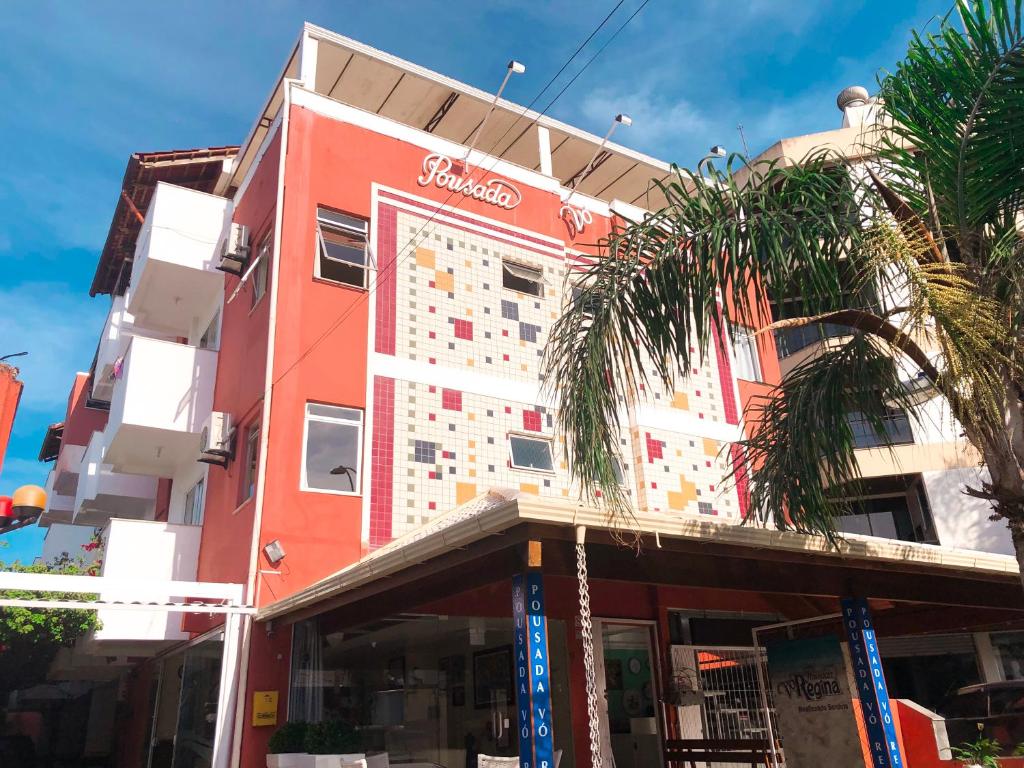 un edificio rojo con un cartel en el costado en Pousada Vó Regina, en Florianópolis