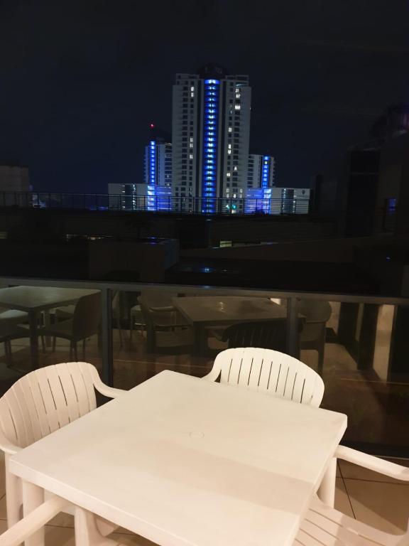 a white table and chairs with a city skyline at night at Sue Beacon Rock in Durban