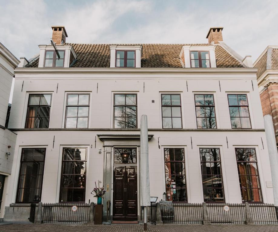 a white house with windows and a roof at Brass in Utrecht