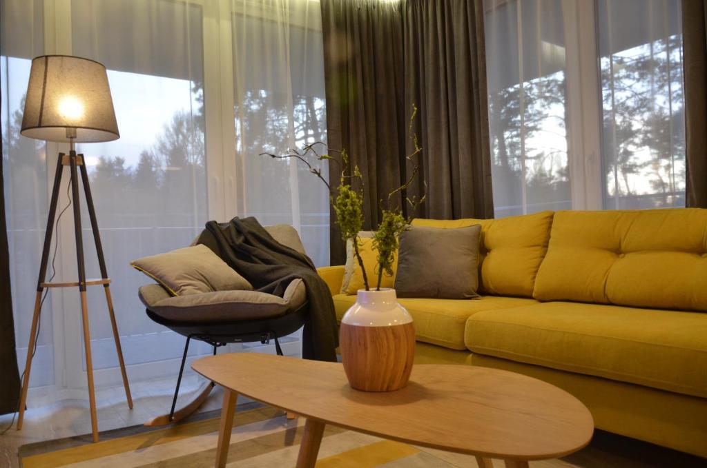 un soggiorno con divano giallo e tavolo di "11" SŁOŃCE WODA LAS - Apartament No11 Garaż w cenie a Kielce