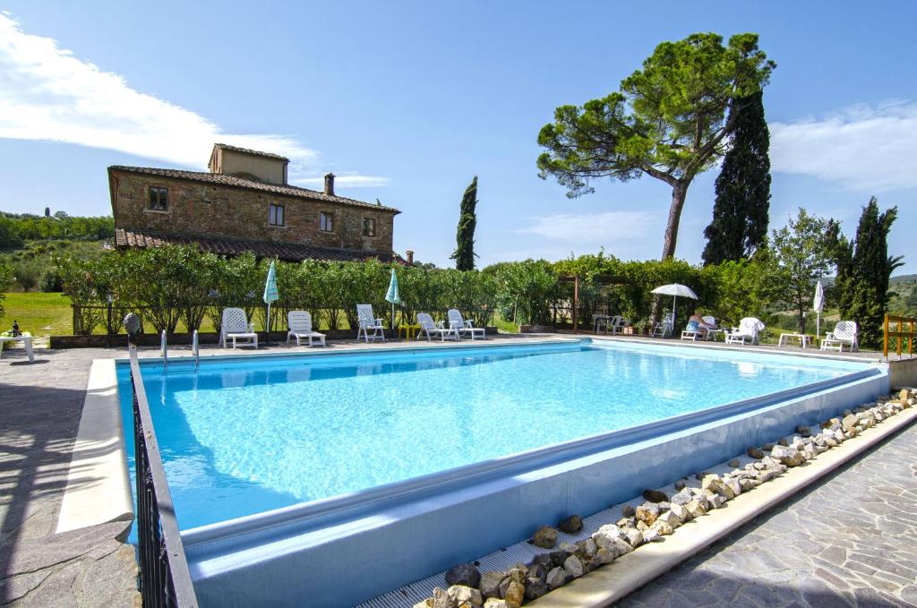 una piscina con una casa en el fondo en Agriturismo tranquillo e con vista panoramica en Torrita di Siena