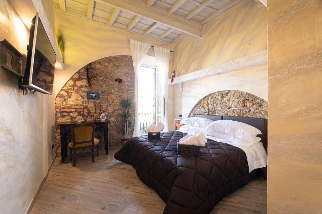 ein Schlafzimmer mit einem großen Bett in einer Steinmauer in der Unterkunft Lo Scoglio dei Volsci in Nettuno