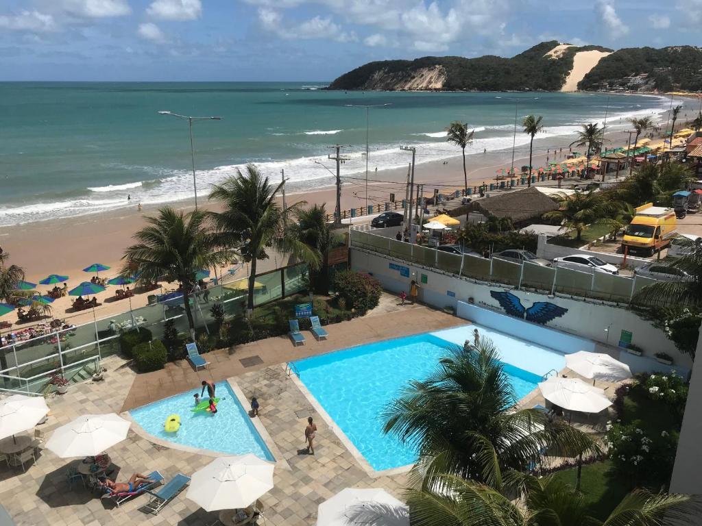 uitzicht op het strand vanaf het balkon van een resort bij Ponta Negra Beach Praiano Flat in Natal