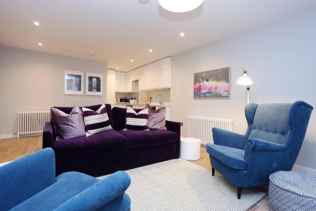 a living room with a couch and two chairs at ALTIDO Vibrant 2 Bedroom Apartment in City Centre in Edinburgh