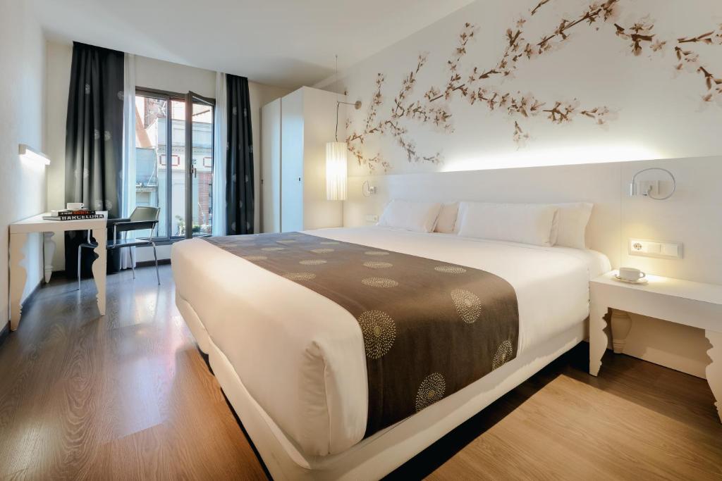 a hotel room with a large bed and a large window at RAMBLAS HOTEL powered by Vincci Hoteles in Barcelona