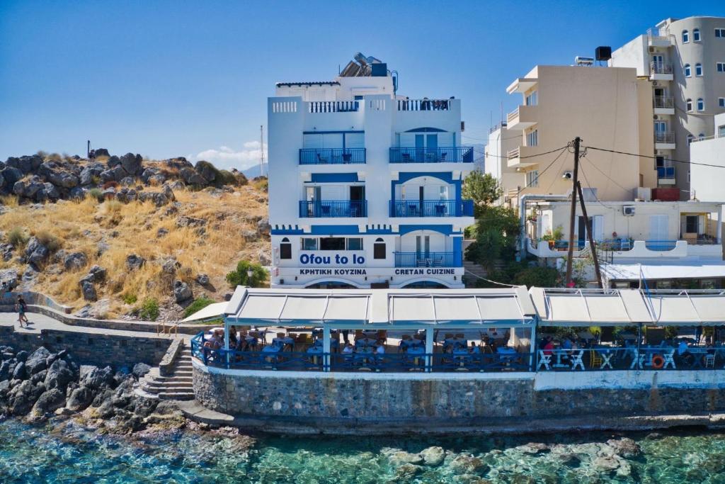 un bateau dans l'eau devant un bâtiment dans l'établissement Sea View Apartments, à Agios Nikolaos