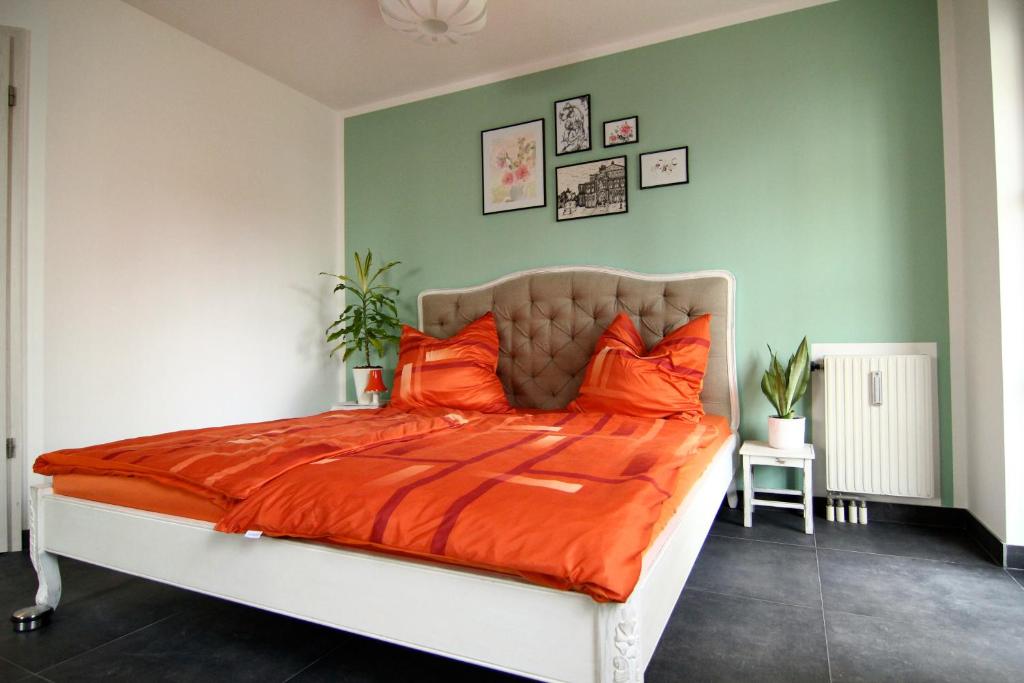 una camera da letto con un letto con cuscini arancioni di Apartment / Flat / Wohnung im Herzen von Dresden a Dresda