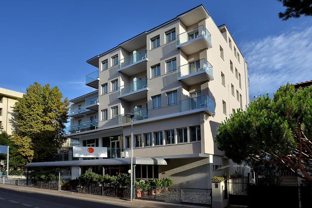 un edificio de apartamentos alto en el lateral de una calle en Hotel Tiberius, en Rímini