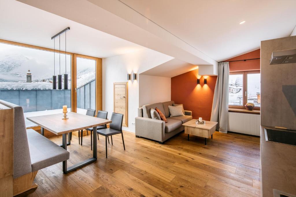 uma sala de estar com uma mesa e um sofá em Fernsicht Alpen-Apartments em Lech am Arlberg