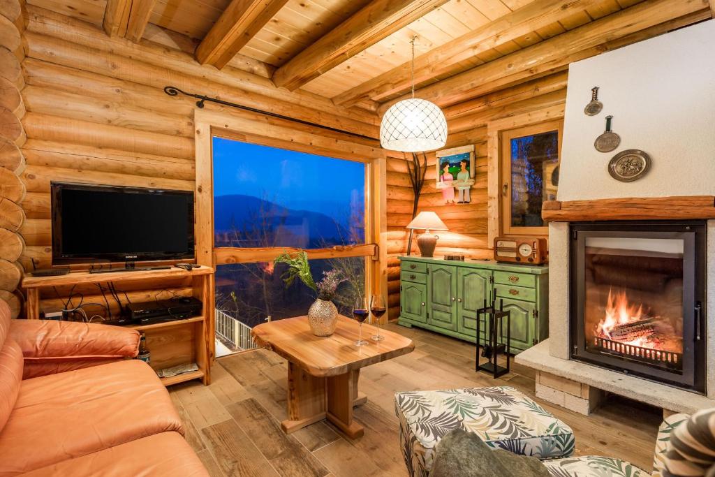 a living room with a fireplace in a log cabin at Mountain family home Nola Ivano in Delnice