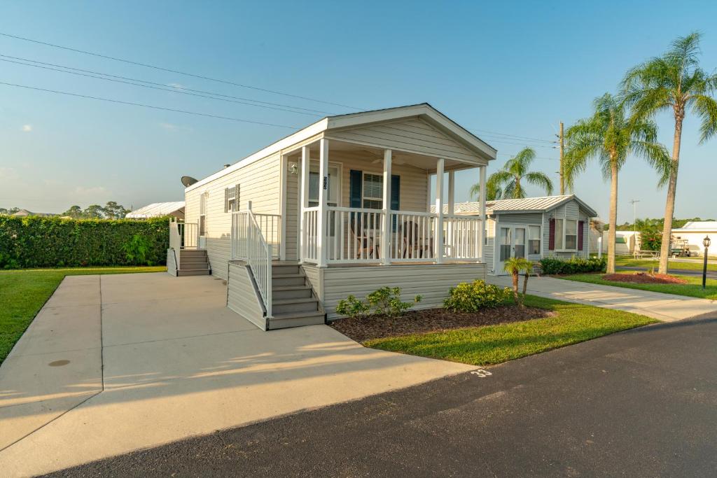 a small white house with a porch on a street at Buttonwood Bay in Sebring