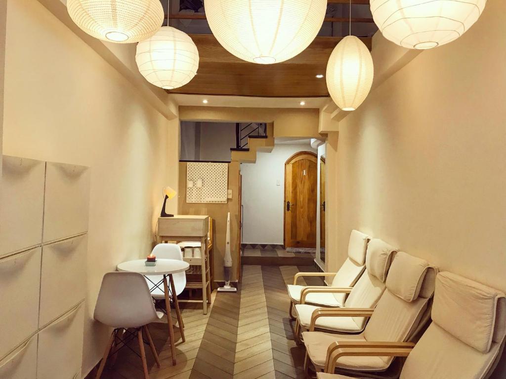 een wachtkamer met stoelen, een tafel en verlichting bij Meow Hotel & Cafe in Ho Chi Minh-stad