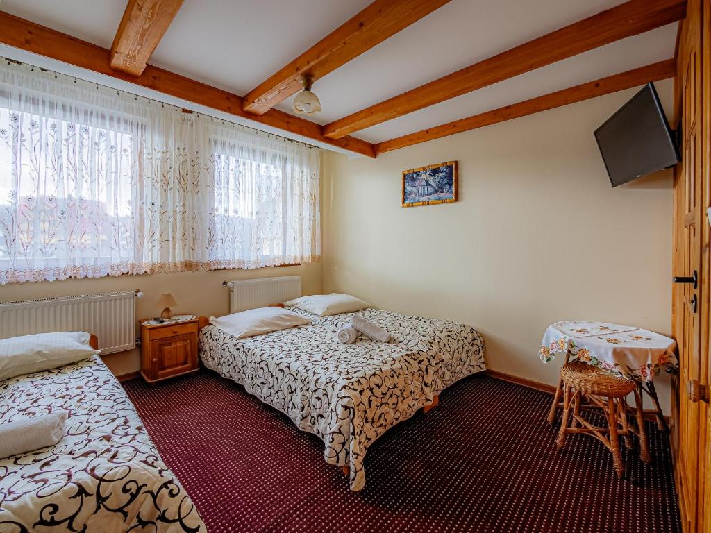 a hotel room with two beds and a tv at Dom Wypoczynkowy u Gałów in Białka Tatrzańska